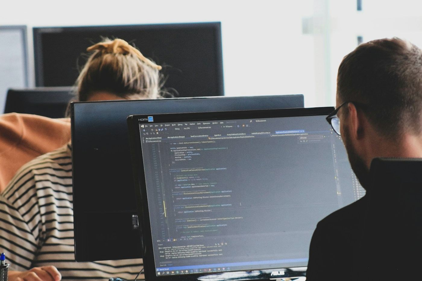 An engineer reviewing code on a monitor